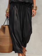 Top smanicato con scollo all'americana e pantaloni plissettati