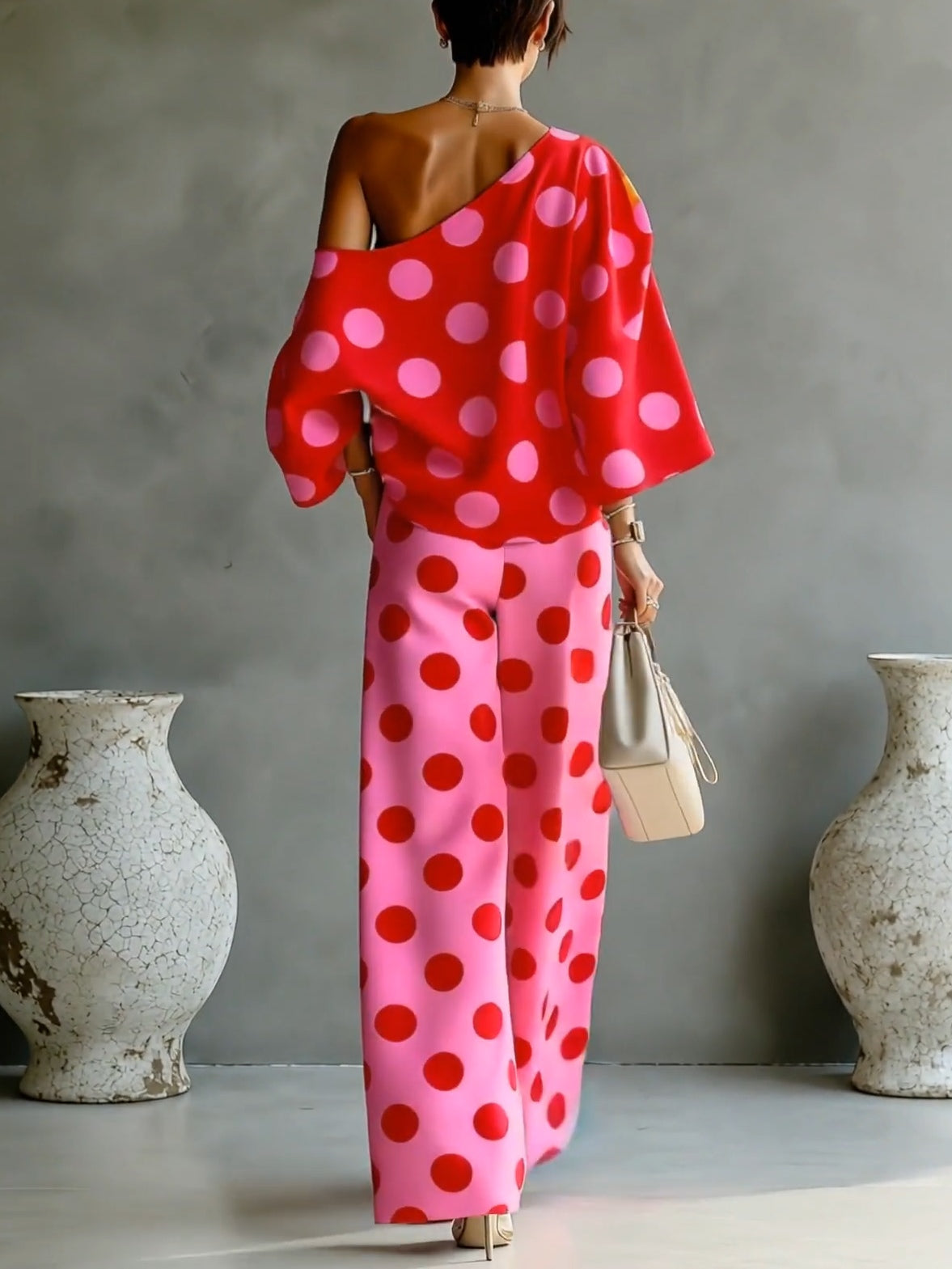 Completo due pezzi con top scollato asimmetrico a pois rosa retrò e pantaloni ampi
